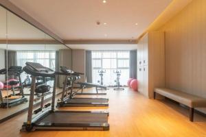 ein Fitnessstudio mit mehreren Laufbändern in einem Raum in der Unterkunft Echarm Hotel Aegean Shopping Park Zhonghuan Plaza in Fujiatun