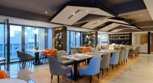 a restaurant with a long table and chairs at Borrman Hotel Guiyang Guanshanhu International Conference Center Metro Station in Jinzhuzhen