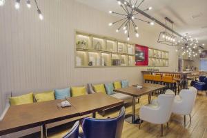 a restaurant with tables and chairs in a room at Echarm Hotel Xinyu Railway Station Baoshi Park in Xinyu