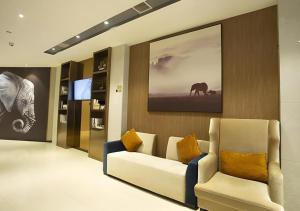 a living room with a couch and an elephant on the wall at Jtour Inn Huanggang Wuxue City Square in Wuxue