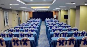 ein Konferenzraum mit blauen und weißen Stühlen und einer Leinwand in der Unterkunft Echarm Hotel Xian Ming City Wall South Gate in Xi'an