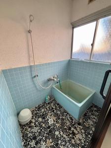 een badkamer met een ligbad en een toilet bij STEP HOUSE -The river side- in Hagi