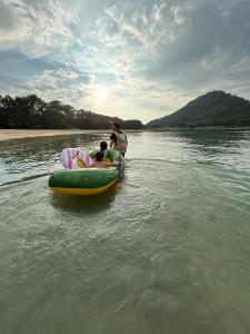 een man en een kind op een vlot in het water bij STEP HOUSE -The river side- in Hagi +7 foto's