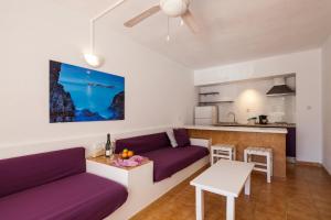 a living room with a couch and a table at Aparthotel Puerto Cala Vadella in Cala Vadella