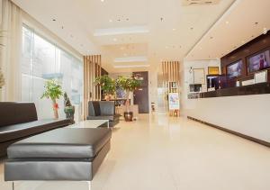 eine Lobby mit Sofas und Tischen in einem Gebäude in der Unterkunft City Comfort Inn Liuzhou The Mixc Xijiang Road in Liuzhou