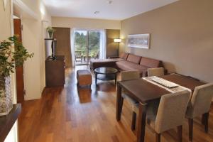 uma sala de estar com um sofá e uma mesa em Altos de Belgrano Hotel Cabañas Golf y Spa em Villa General Belgrano