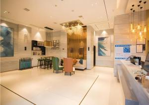 eine Lobby mit einem Tisch und Stühlen in einem Zimmer in der Unterkunft City Comfort Inn Nanchang Guanying Road Metro Station Maya Paradise in Nanchang