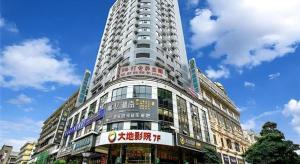 a tall building with a sign on the side of it at City Comfort Inn Wuzhou Arcade City Sanzongfu in Wuzhou