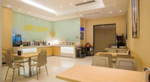 a restaurant with tables and chairs in a room at City Comfort Inn Liuzhou High-speed Railway Station in Liuzhou