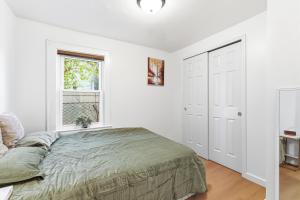 a white bedroom with a bed and a window at Hamilton in Harrison