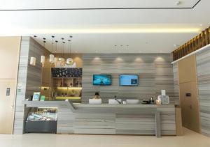 a woman sitting at a counter in a store at City Comfort Inn Guigang Hecheng Wanda Plaza in Guigang