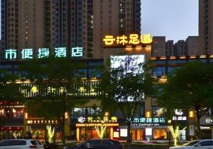 a building with neon signs in a city at night at City Comfort Inn Jingzhou Greenland Overseas Beach Wuyue Plaza in Shashi