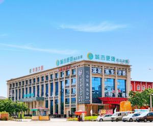 ein großes Gebäude, vor dem Autos parken in der Unterkunft City Comfort Inn Dongguan Zhongtang in Zhongtang