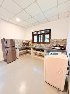 Una cocina con refrigerador de acero inoxidable en una habitación. en Dushan's House, en Ahangama