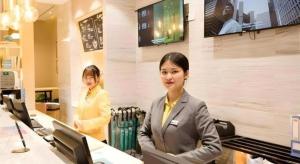 two women standing in an office with at City Comfort Inn Guigang Zhongshan High Speed Railway Station in Guigang