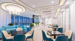 a waiting room with blue chairs and tables in a building at Xana Hotelle· Wulumuqi High Speed Railway Station Baonengcheng in Ürümqi