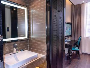 ein Bad mit einem Waschbecken, einem Spiegel und einem Schreibtisch in der Unterkunft Xana Hotelle Nanchang Tengwang Pavilion Qingshan Road Metro Station in Nanchang County