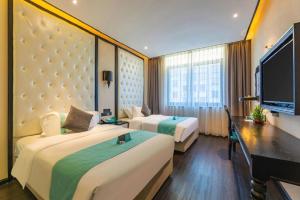 ein Hotelzimmer mit zwei Betten und einem Flachbildfernseher in der Unterkunft Xana Hotelle Nanchang Tengwang Pavilion Qingshan Road Metro Station in Nanchang County