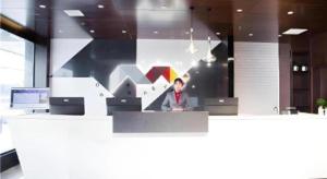 a man sitting at a counter in an office at Borrman Hotel Huanggang Wuxue Yuhu Road in Wuxue