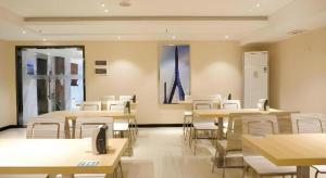 une salle à manger avec des tables et des chaises et un tableau dans l'établissement City Comfort Inn Dongguan Shijie Jiarong Shopping Plaza, à Shilong