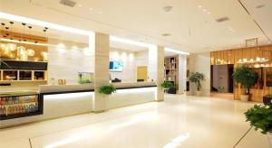 ein großer Raum mit einer Lobby mit Pflanzen darin in der Unterkunft City Comfort Inn Xiaogan Hubei Engineering College in Xiaogan