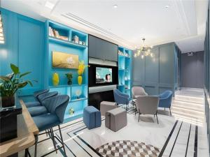 a living room with blue walls and chairs at Magnotel Hotel Suzhou Wanda Plaza Huaihai Road in Suzhou