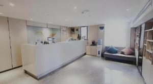 ein großer weißer Raum mit Küche und Couch in der Unterkunft Green Tree Inn Express Shanghai Bund Yuyuan Xiaonanmen Metro Station in Shanghai