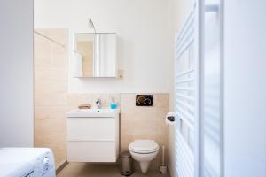 ブダペストにあるExecutive Apartmentの白いバスルーム(トイレ、鏡付)