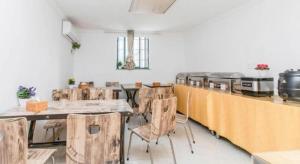 ein Raum mit Holztischen und -stühlen und einer Küche in der Unterkunft City Comfort Inn Nanchang Bayi Square Metro Station Wushang in Nanchang