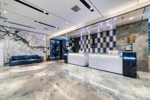 eine Lobby mit einem blauen Sofa und einem Tisch in der Unterkunft Echarm Hotel Nanjing Lishui High-speed Railway Station Wuzhou Commercial City in Lishui