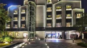 a large building with a lit up facade at night at Immersing Hotels & Resort Yunzhu Meiyuan Wuyishan Impression Dahongpao in Wuyishan