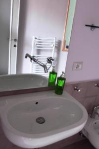 a bathroom with a sink and a mirror and a chair at Villa Manasse in Aci Castello