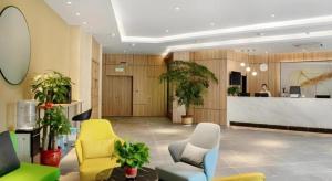 a lobby with chairs and a counter in a building at Green Tree Inn Express Huai'an Huaiyin District Jiangxi Road Normal University in Huai'an
