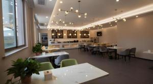 ein Restaurant mit Tischen und Stühlen in einem Raum in der Unterkunft Green Tree Inn Anhui Suzhou Evergrande in Suzhou