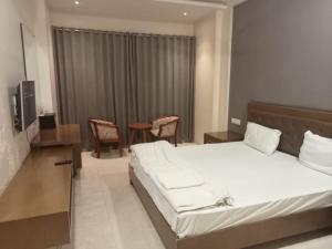 Ένα ή περισσότερα κρεβάτια σε δωμάτιο στο Hotel Atharva