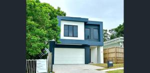 ein blau-weißes Haus mit Garage in der Unterkunft Sunnybank Station 5B Family Stay in Brisbane