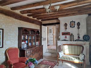 a living room with a chair and a book shelf at Chambres d'Hôtes L'Ecu in Preuilly-sur-Claise
