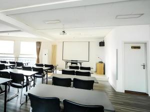 ein Klassenzimmer mit Tischen, Stühlen und einem Whiteboard in der Unterkunft GreenTree Alliance Hotel Qinghuangdao Wanda Plaza in Qinhuangdao