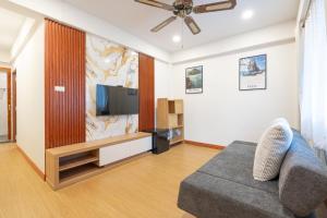 a living room with a couch and a flat screen tv at The Banyan House in Patong Beach