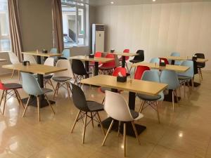 a group of tables and chairs in a room at GreenTree Inn Dalian Jinzhou District Railway Station Ansheng Plaza in Jinzhou