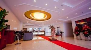 a living room with a large ceiling with a red rug at GreenTree Inn Dalian Jinzhou District Railway Station Ansheng Plaza in Jinzhou
