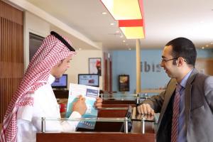 فندق إيبيس الرياض شارع العليا في الرياض: رجلان يقفان في متجر ويتحدثان مع زبون