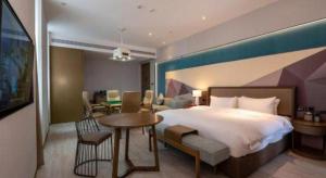 une chambre d'hôtel avec un grand lit et une table dans l'établissement GreenTree Eastern Hotel Nanning Wuxiang Hangyang City, à Nanning 272 autres photos