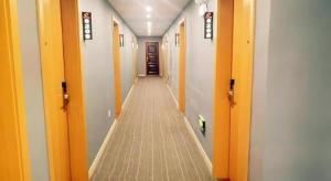 a hallway with orange doors and a long aisle at Shell Hotel Jiangsu Taizhou Hailing District Taizhou Avenue in Sixiang +21 photos