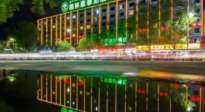a building at night with a reflection in the water at Green Tree Inn Tibet Lhasa Zhaji Temple in Lhasa
