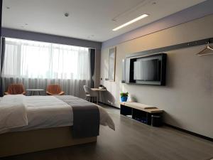 ein Schlafzimmer mit einem Bett und einem Flachbildfernseher in der Unterkunft Thank Inn Ningxia Yinchuan Helan County Ningxia Jiaotong School in Fengdeng