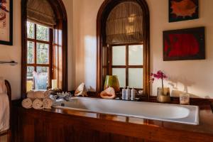 a bathroom with a sink and a large mirror at Hemingways Eden Residence in Nairobi +56 photos