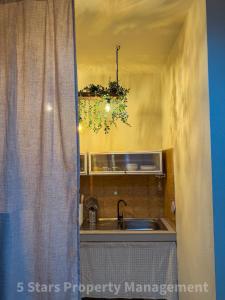 eine Küche mit einem Waschbecken und einem Fenster mit einem Vorhang in der Unterkunft Boho-Vibes with Soft Beds, Cozy Balconies and Sport equipment in Haad Pleayleam