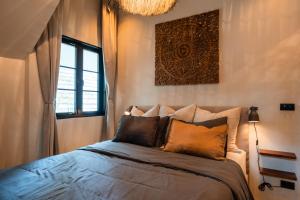 ein Schlafzimmer mit einem Bett mit Kissen darauf in der Unterkunft The Tropical Boho Bungalow in Phra Ae beach