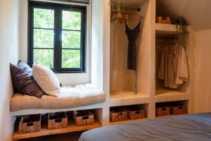 ein Schlafzimmer mit Fenster und einer Bank mit Körben in der Unterkunft The Tropical Boho Bungalow in Phra Ae beach